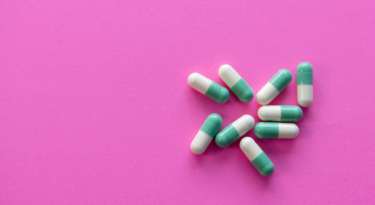 Blue and white pills on a hot pink background.