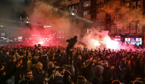 What sparked violent clashes between football fans in Amsterdam?